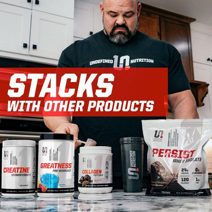 Brian Shaw in a kitchen with Undefined Nutrition products displayed on the counter.