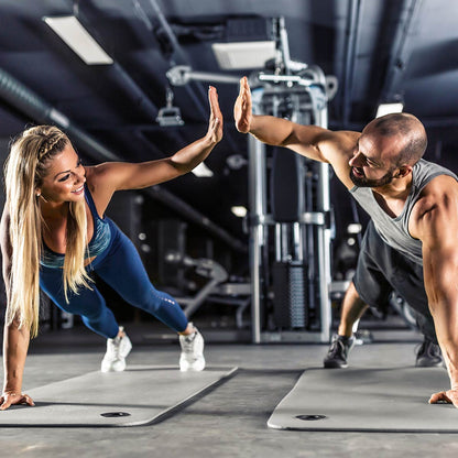 Two people doing push-ups in a gym setting
